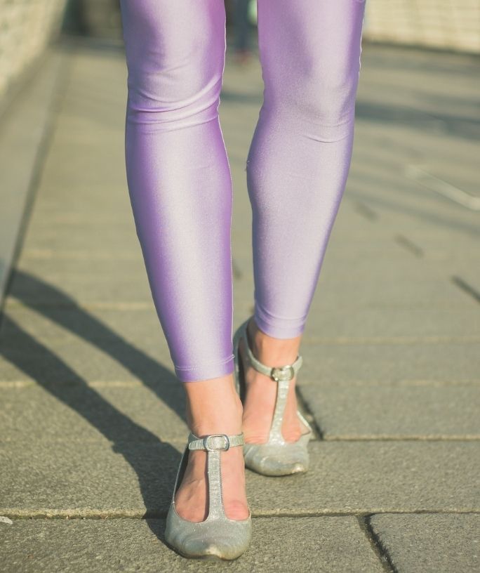 the lower half of a woman's legs, clad in pastel purple leggings