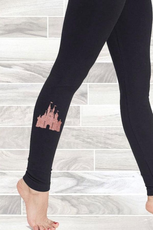 a black pair of leggings with a sparkly pink Disney castle on them