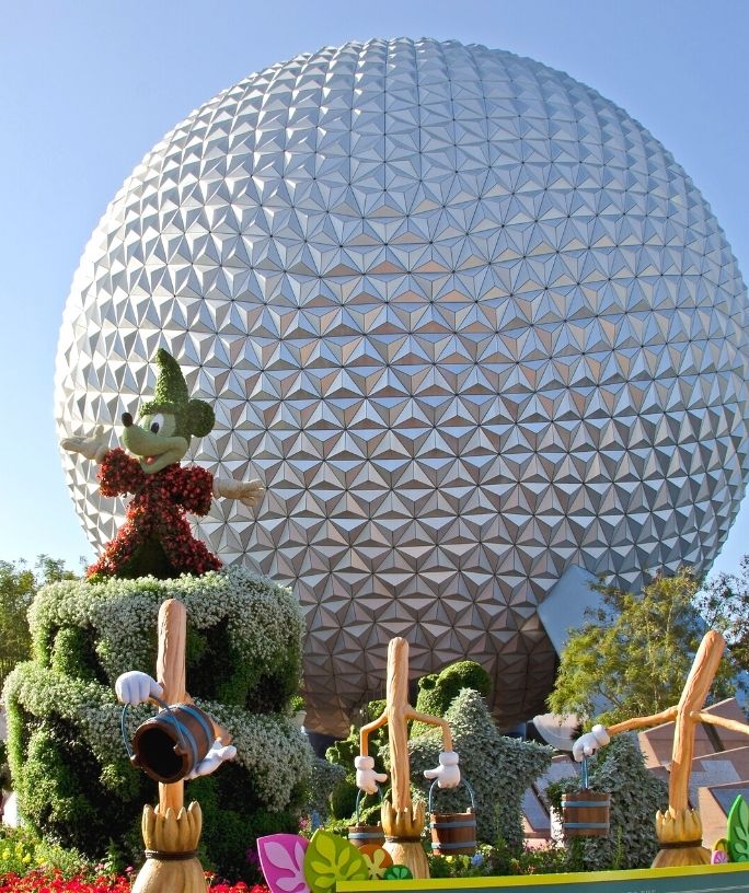 Spaceship Earth from Epcot in the background, with a topiary Mickey in the foreground
