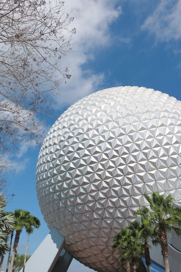 closeup of the Epcot ball (Spaceship Earth) during the daytime, with palm trees flanking it
