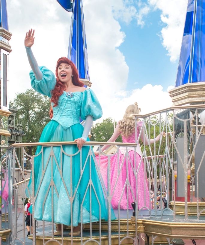 Princess Ariel and Princess Aurora on a parade float in the Magic Kingdom of Walt Disney World