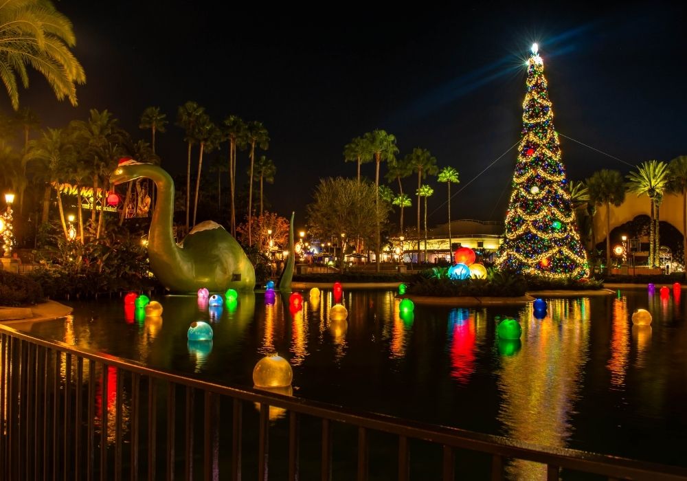 Echo Lake at Hollywood Studios features Gertie the dinosaur decked out in holiday decor, alongside a Christmas tree