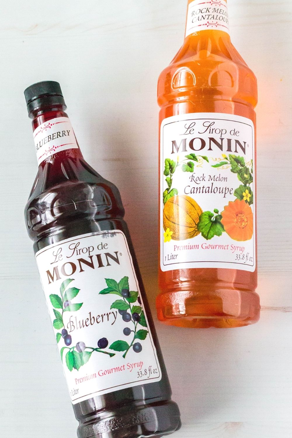 a bottle of monin blueberry syrup and monin rock melon cantaloupe syrup