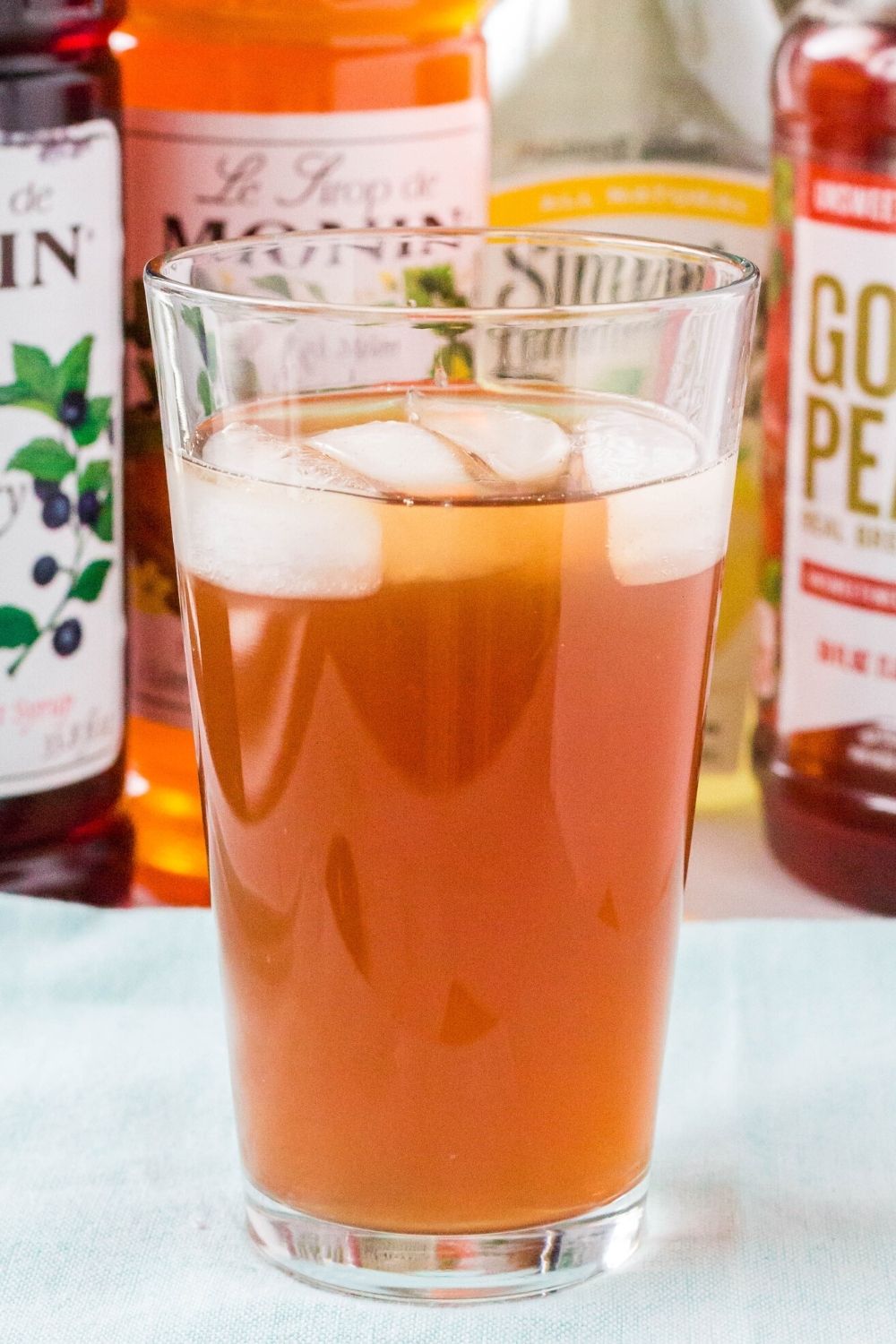 a pint glass filled with Tatooine Sunset beverage, in front of the ingredients for the recipe