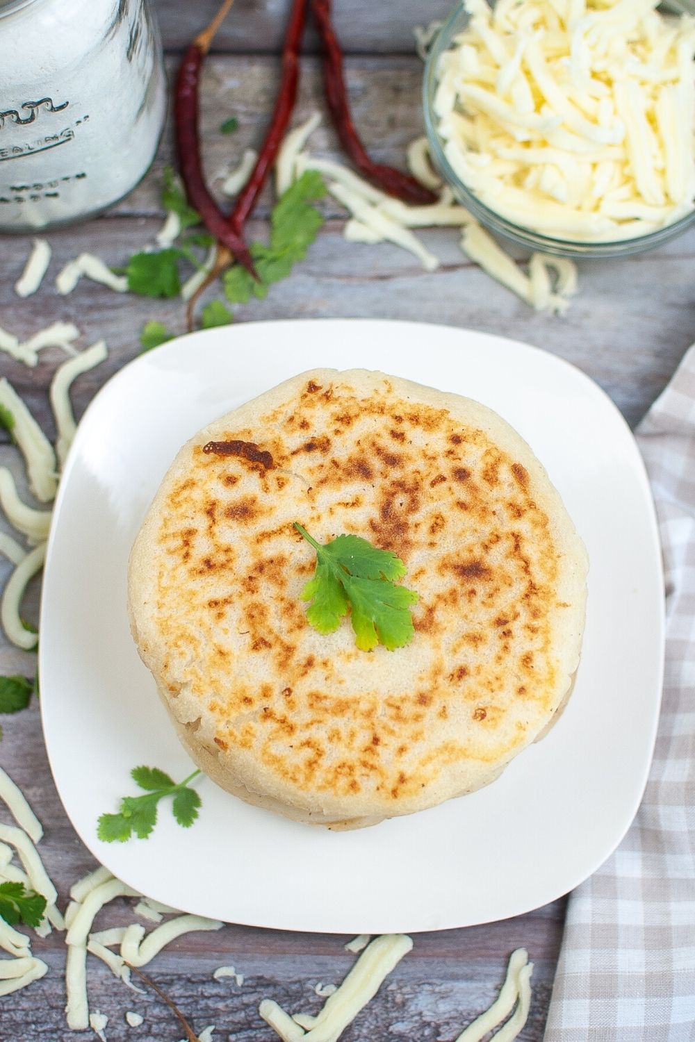 overhead view of a stack of homemade arepas on a white plate