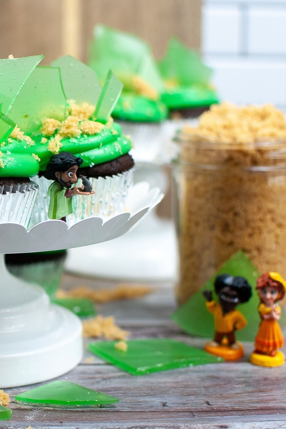 Bruno's vision cupcakes on a cake stand, with figurines of Bruno, Felix, and Pepa.