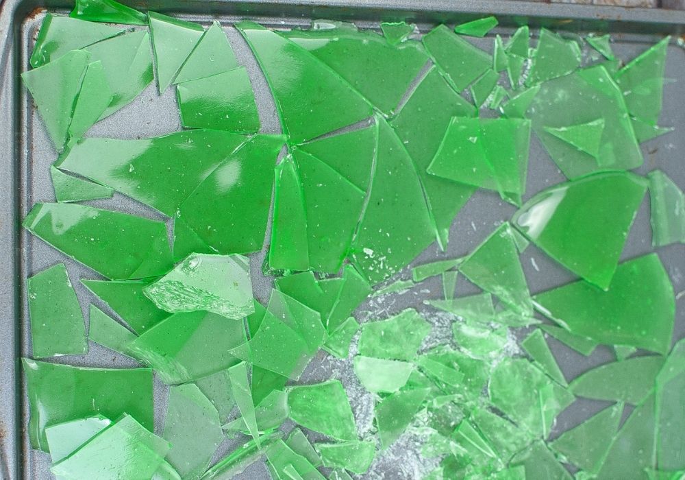 green candy glass broken into pieces on a baking sheet, ready to decorate encanto themed cupcakes