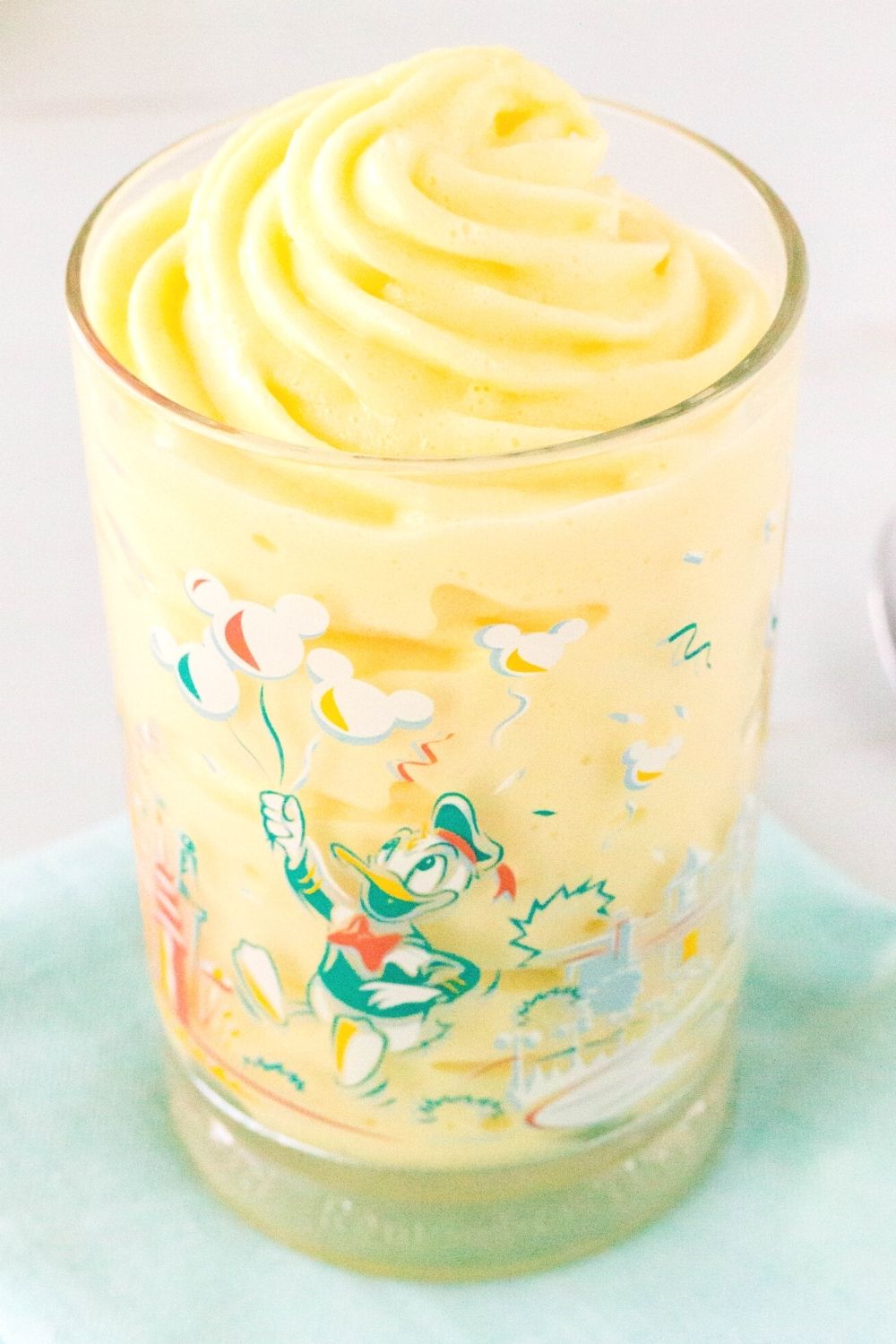 homemade Pineapple Dole Whip served in a Disney glass with Donald Duck on it