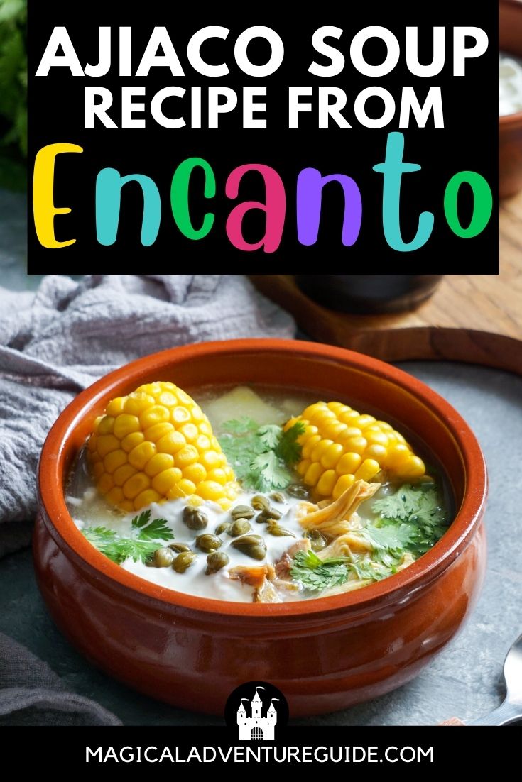 an orange bowl filled with ajiaco soup of corn, potatoes, and chicken. An overlay reads, "Ajiaco Soup Recipe from Encanto"