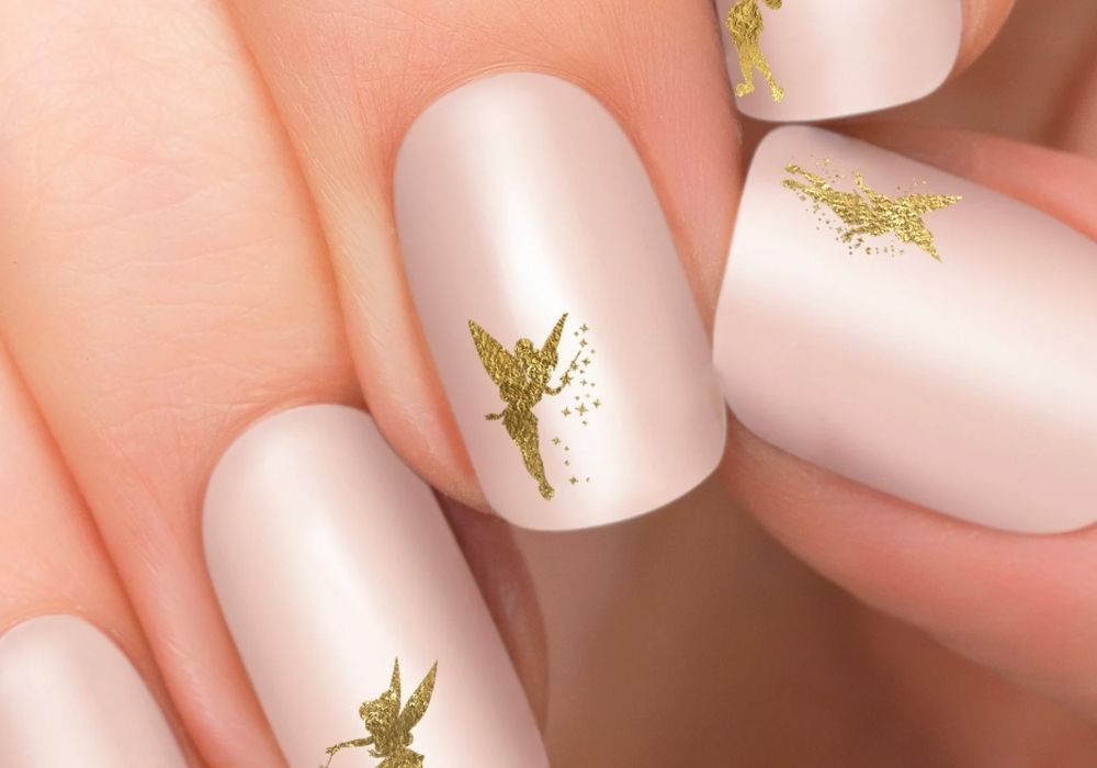 gold sparkle tinkerbell decals applied to pink fingernails