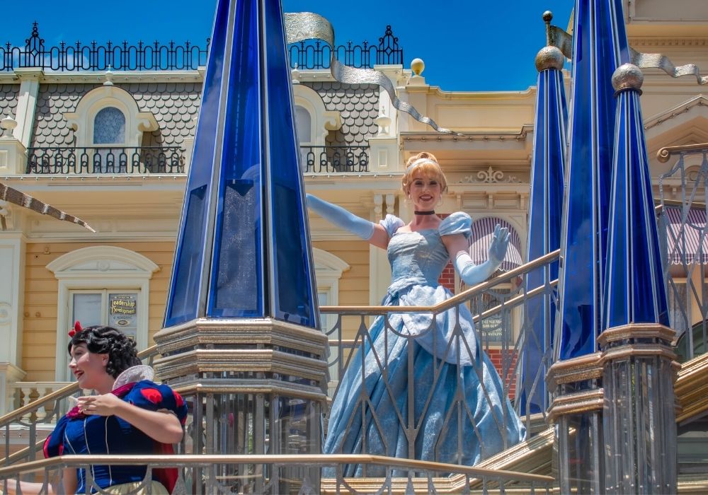 Cinderella and Snow White wave from parade floats on Main Street USA