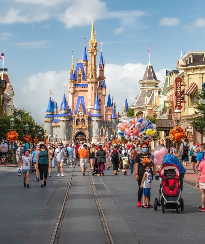 guests stroll down Main Street USA and pose for pictures in front of Cinderella's Castle at Magic Kingdom in Disney World