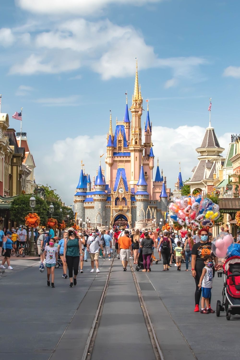 Guests walk down Main Street USA and pose for photos in front of Cinderella's Castle