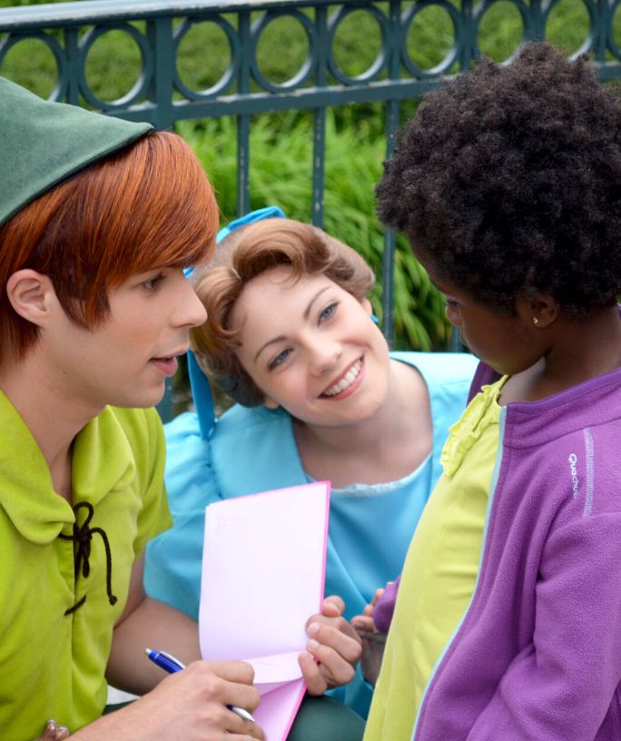 Peter Pan and Wendy characters at Disney World talk to a child