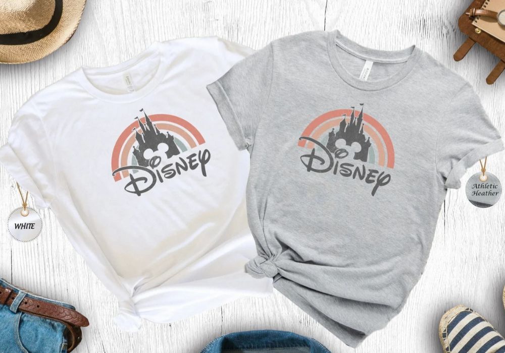 white and gray shirts with matching Disney logo and castle icon, with a rainbow backdrop