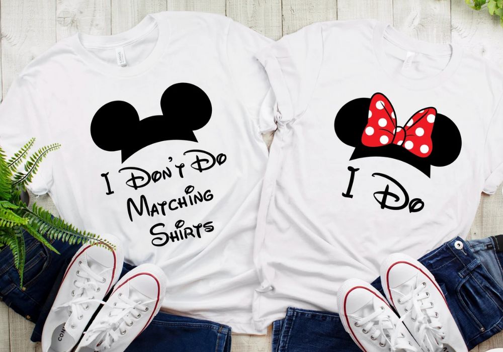 two white t-shirts with mickey and minnie ears on them. One says, "I don't do matching shirts" and the other says, "I do"