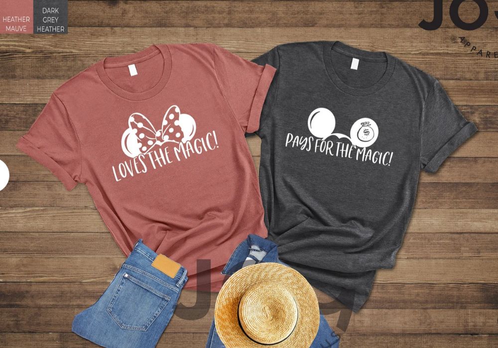 pink and gray shirts. One says, "Loves the Magic" and one says "Pays for the Magic"