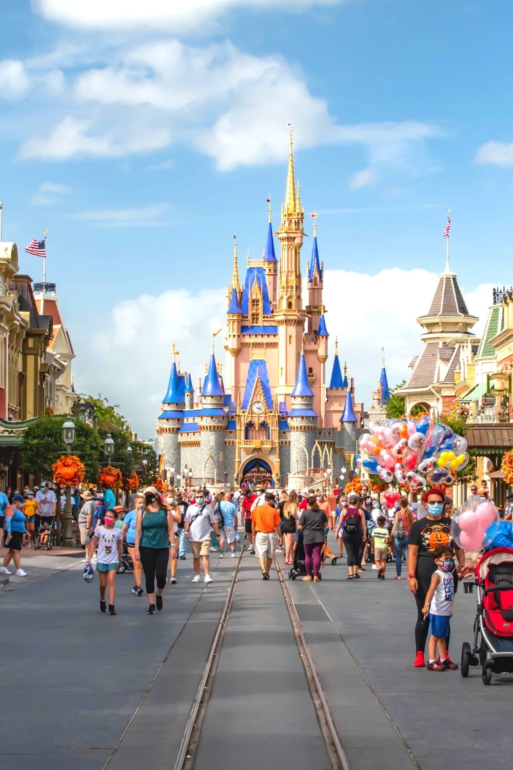 guests visit the Magic Kingdom in the fall, with Cinderella's Castle in the background