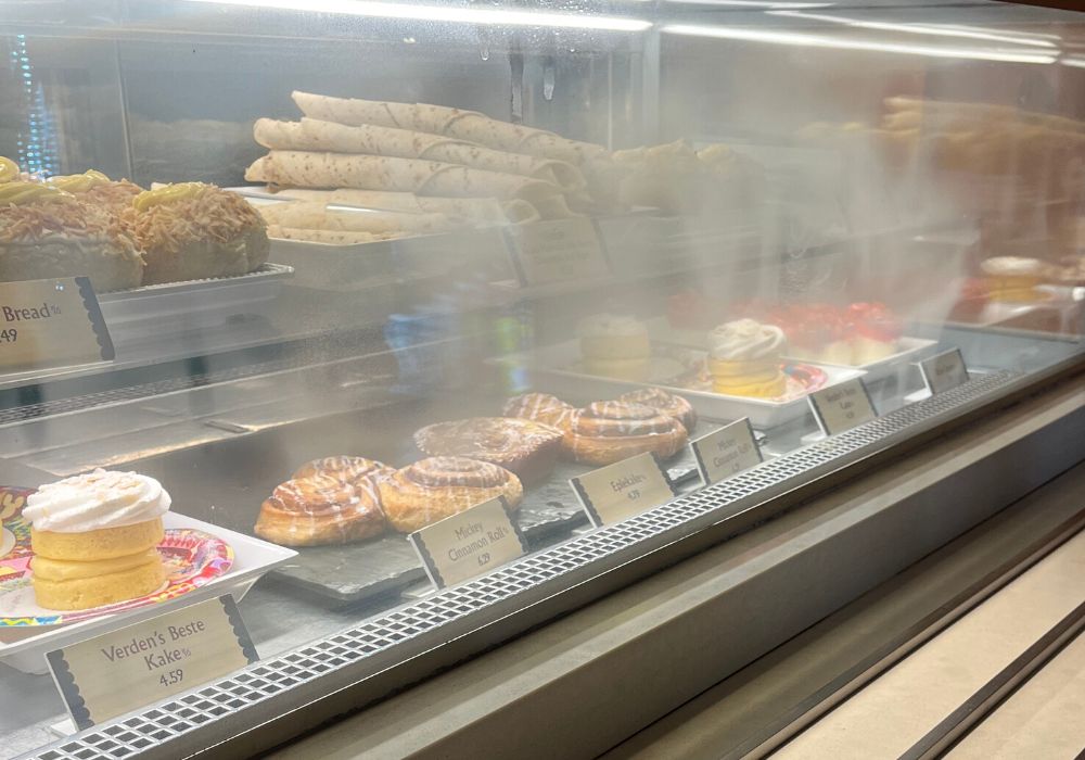 bakery case at Kringla Bakeri Og Cafe in Epcot, featuring various sweet treats, including Mickey cinnamon rolls for breakfast
