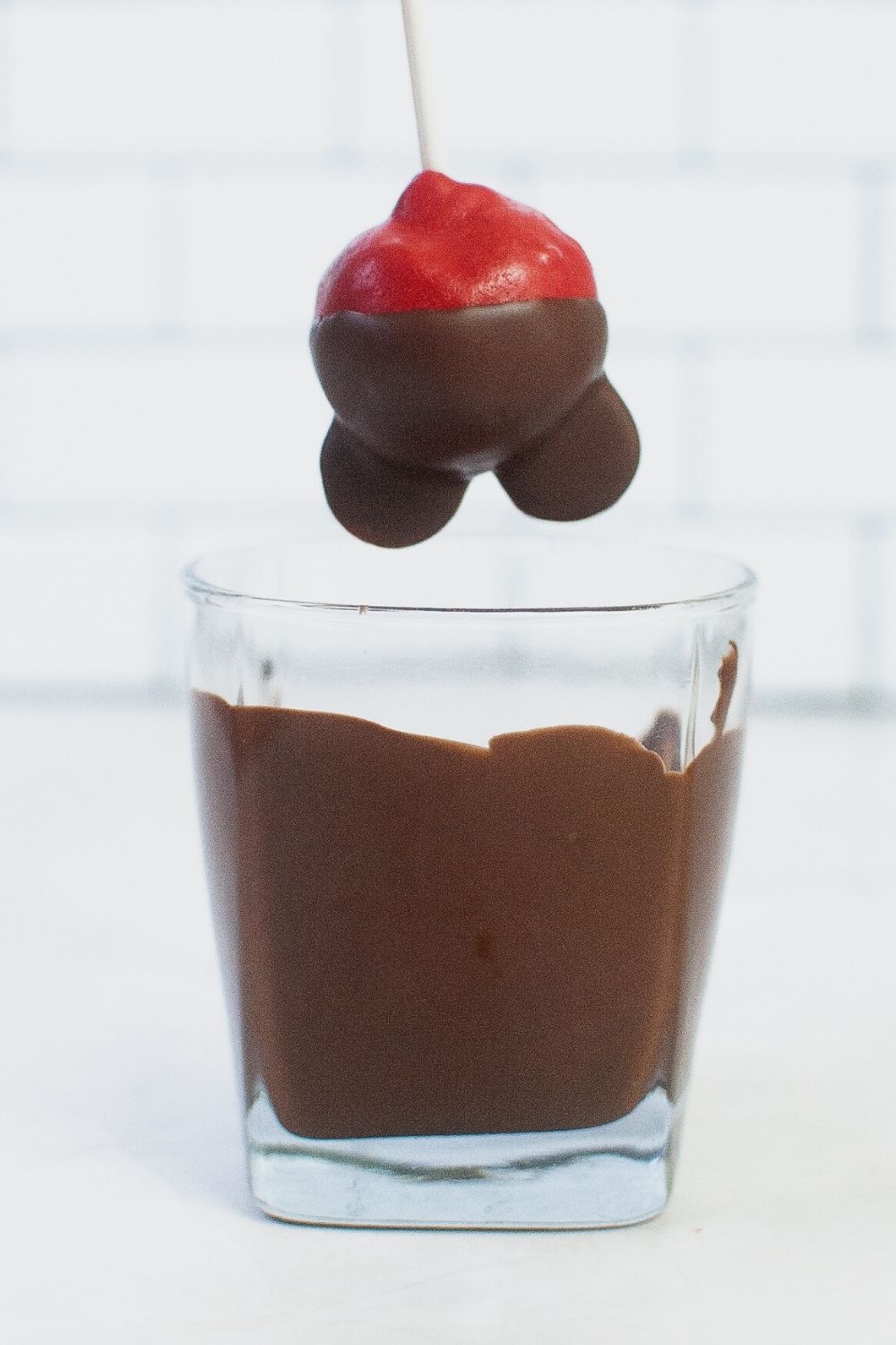 cake pop with Mickey ears dipped into melted chocolate almond bark
