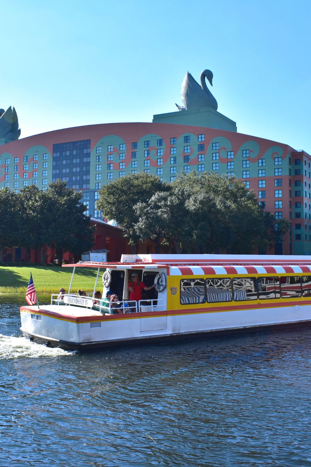 a Friendship Boat sails past the Disney Swan and Dolphin hotel, one of the resorts with a spa where you can obtain a massage at Disney World.