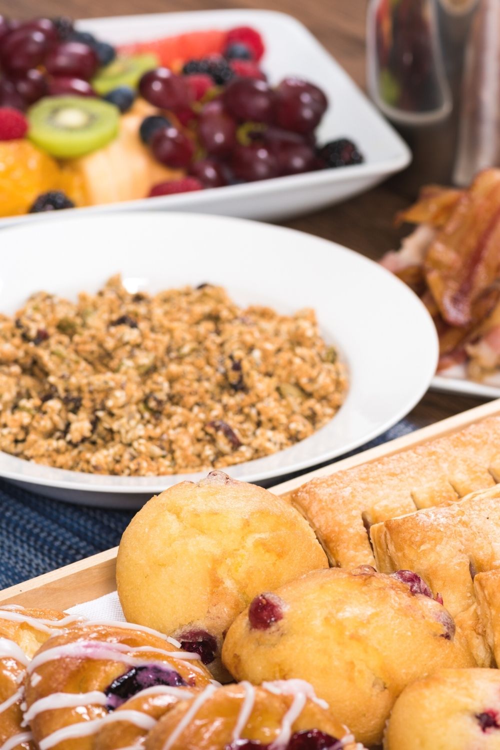 breakfast buffet featuring danishes and pastries, granola, bacon, fresh fruit, and more.